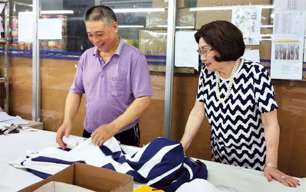 Mok Sau-jean (right), a seasoned fashion professional from Hong Kong, inspects her workshop in Zhongshan and talks with an employee. Mok Sau-jean (right), a seasoned fashion professional from Hong Kong, inspects her workshop in Zhongshan and talks with an employee.