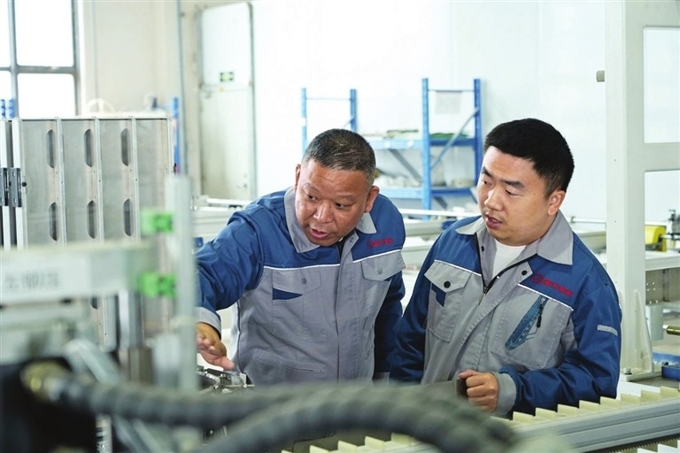 ▲XG Intelligent president Fu Mingtao (L) discusses technical solutions with an engineer in the workshop.